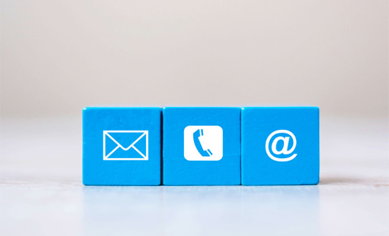 tre piccoli cubi con simboli di busta, telefono e email